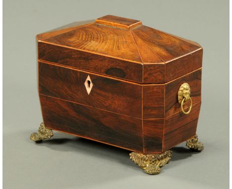 A Regency rosewood tea caddy, boxwood strung and with brass handles and feet (see illustration).  