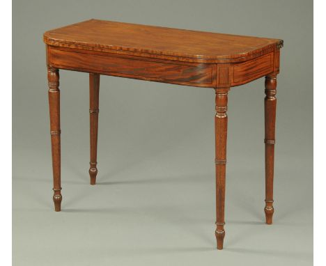 A George III mahogany ebony strung turnover top card table, raised on turned tapered legs.  Width 91 cm (see illustration). 