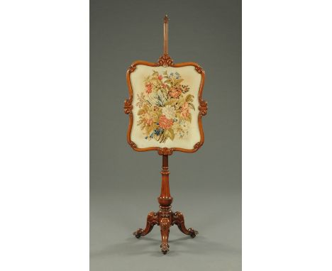 A Victorian mahogany framed pole screen, with woolwork tapestry, raised on a turned column with three downswept legs terminat