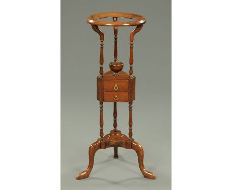 A George III mahogany basin stand, with circular top, fitted with two small drawers and low shelf and raised on cabriole legs