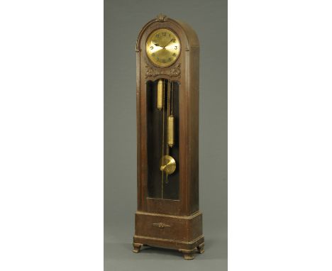 An oak cased longcase clock, 1930's, the circular dial with Arabic numerals and with weight driven movement.  Height 200 cm. 