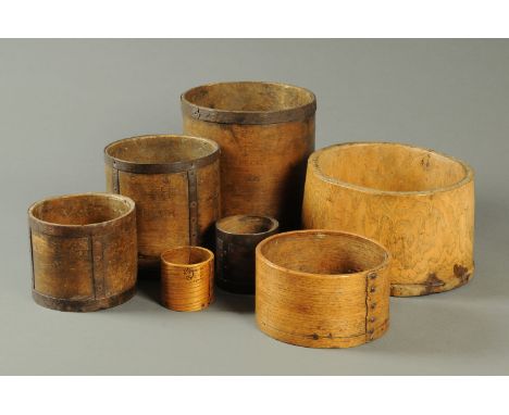 Six 19th century beechwood measures, peck to half pint, and a large Treen handled measure (see illustration).   CONDITION REP