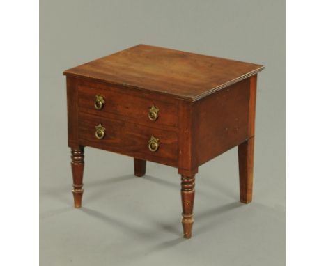 A Regency mahogany commode, with lift up top and fitted interior, the front modelled as two drawers and raised on turned legs
