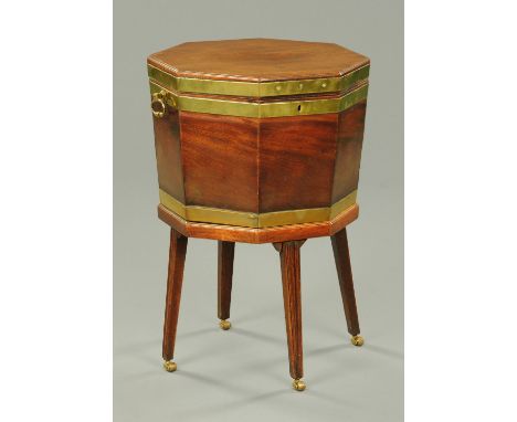 A George III octagonal brass bound mahogany cellarette on stand, with lead lined interior, carrying handle to either side and