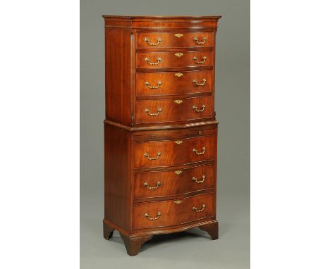 A mahogany reproduction serpentine fronted chest on chest, with four drawers to the upper section and with slide and three fu