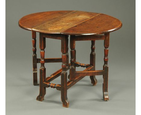 An antique oak gate leg table, of small size, with demi-lune flaps, turned legs and stretchers.  Width 91 cm.    CONDITION RE