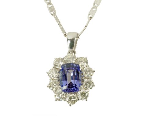 An 18 ct long cushion cut tanzanite and diamond cluster pendant, tanzanite weight +/- 5 carats (see illustration).