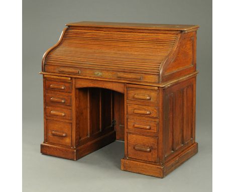 An early 20th century oak roll top desk, with fitted interior and with four drawers to each pedestal with wooden handles.  Wi