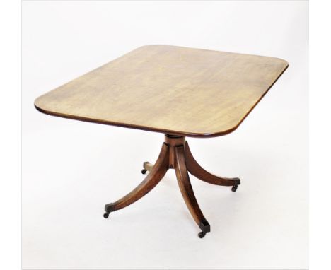 A George III mahogany pedestal breakfast table, circa 1800, the rectangular top with rounded corners, raised upon a ring turn