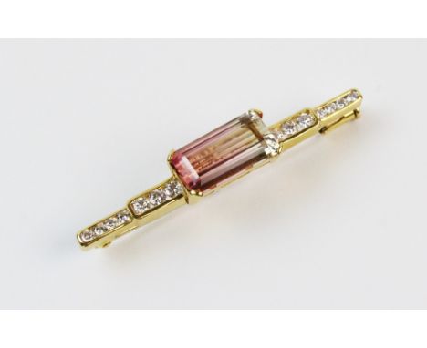 A tourmaline and diamond set bar brooch, the rectangular step cut watermelon tourmaline measuring 14mm x 7mm, flanked by seve