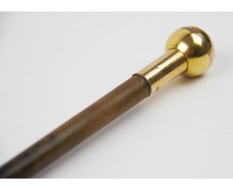 An 18ct gold plate mounted Rhino horn swagger stick, of slender tapering form terminating with a knop stamped '18ct P.G.', 55