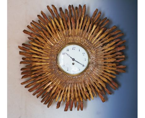 A late 19th century gilt wood sunburst clock, with two graduated tiers enclosing the 16cm white enamel dial with painted Arab