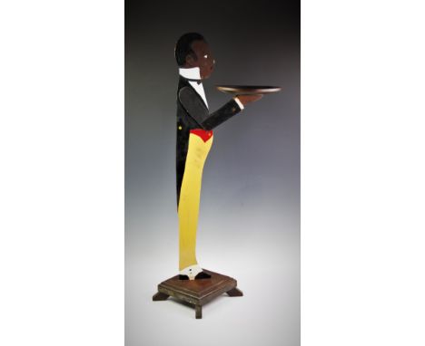 A vintage painted wooden novelty figural key or card stand, with vibrant yellow trousers, upon a plinth base, 93cm 