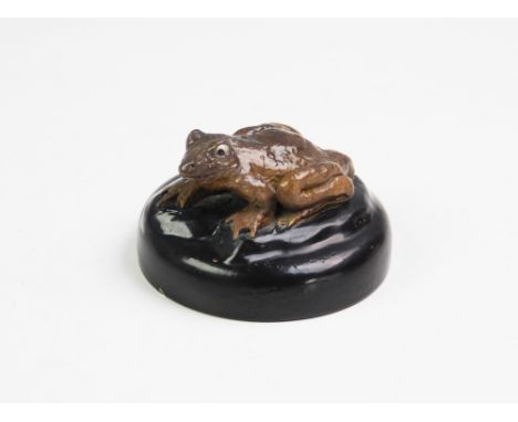 A late 19th century cover, Martin Brothers, modelled as a grotesque frog finial, seated on a black plinth, incised verso '10-