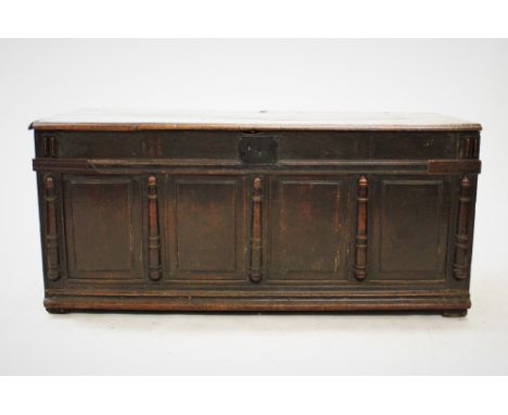 A 17th century and later oak coffer, the rectangular moulded two plank top above four panels flanked by ring turned half pila