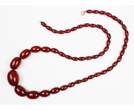 A cherry amber bead necklace, the single strand necklace comprising graduated beads strung on wire, 76cm long, spring ring fa