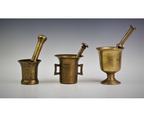 An 18th/19th century brass pestle and mortar, the ring incised mortar of bell form, 9cm high, along with a ring turned pestle
