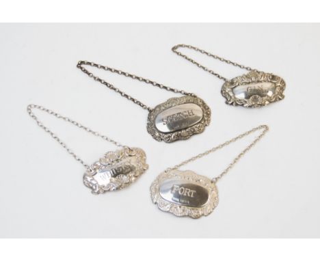 Four silver decanter labels, titled for 'PORT', 'SCOTCH', 'WHISKY' and 'GIN', each border designed with a central shell form 
