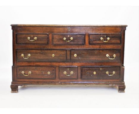 A George III oak and mahogany cross banded Lancashire mule chest, the rectangular moulded hinged top above three faux drawers