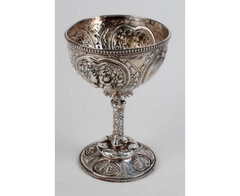 A silver goblet, elaborately embossed with floral motifs and wreaths, from bowl to spreading circular base, the rims beaded a