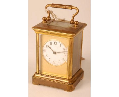 A small French brass corniche carriage clock, the white enamel dial within a gilt plate, height excluding handle 8cm.