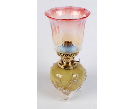 A Williams and Bach small oil lamp with spherical opalescent glass font, naturalistic lamp glass feet and cranberry tinted, v
