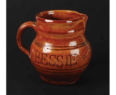 A rare documentary Leach Pottery Michael Cardew jug. The red body incised through slip 'Bessie Stevens 1926', impressed seal 