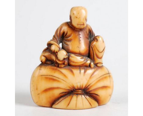 A Japanese ivory late 18th century Kyoto school, netsuke in the form of Hotei seated on a sack.