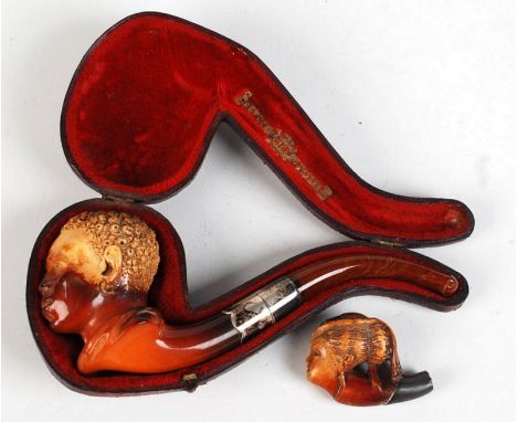 A meerschaum pipe the bowl carved with a negro head by WHC, together with one other small meerschaum pipe.