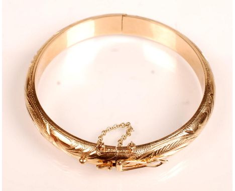 An engraved 18ct. gold bangle.
