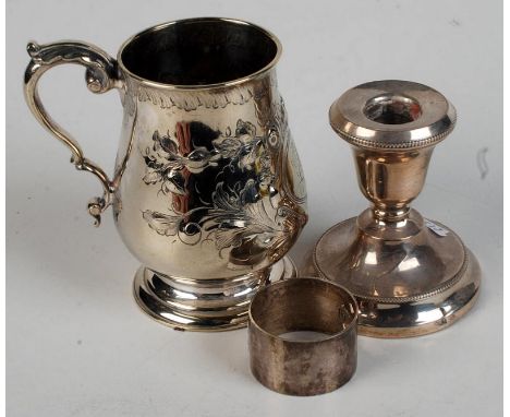 A filled silver candlestick, a floral engraved mug and a napkin ring.