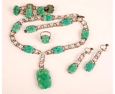 An Art Deco costume jewellery parure, comprising a necklace with moulded 'jade' glass panels and drop. A bracelet, a ring and