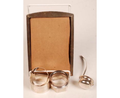 An engine turned silver photograph frame, four napkin rings etc.