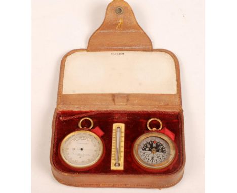 A good Negretti & Zambra pocket gilt brass cased barometer and a matching compass in a fitted leather case divided by a Fahre