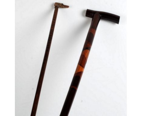 A walking stick made from specimen timbers together with a walking cane with a carved horn dog's head handle.