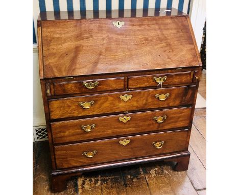 A George III mahogany bureau, circa 1820, fall front enclosing pigeon holes, small drawers and cupboard with a leather inlay 