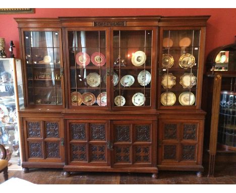 A late Victorian Collinson and Locke walnut breakfront library bookcase, circa 1895, made in London, the upper section fitted