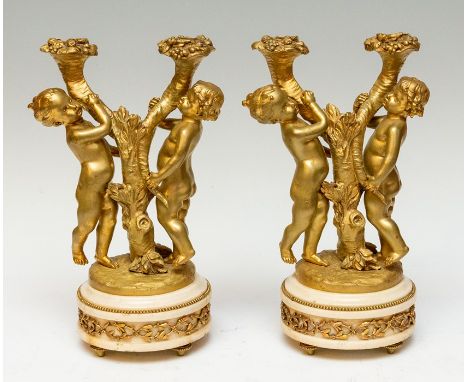 A pair of 19th Century French gilt bronze figural candelabrum, in the form of children holding cornucopia, forming two candle