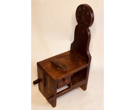 A mid 19th Century grained pine shoe shiners stool, circa 1850, pawn shaped back rest with rectangular seat, fitted with a si