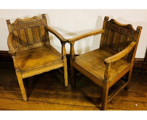 A near pair of early 20th century oak armchairs, scrolled finials and top back rest above five carved mould panel back rest, 