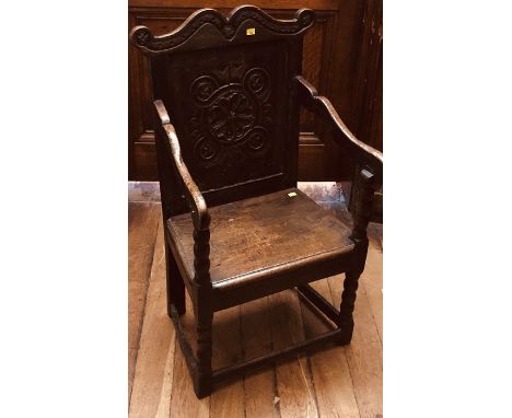 A William and Mary oak wainscot chair, circa 1695, scrolled top above a floral carved panel, united with shaped down scroll a