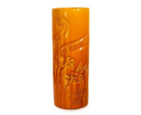 A Bretby Art Pottery large stick stand with moulded dragon decoration, all picked out with vibrant yellow and orange glazes, 