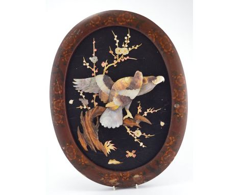 A Meiji period Japanese oval shibayama wall plaque, circa 1870, red lacquered oval frame with blossom detail, black lacquered