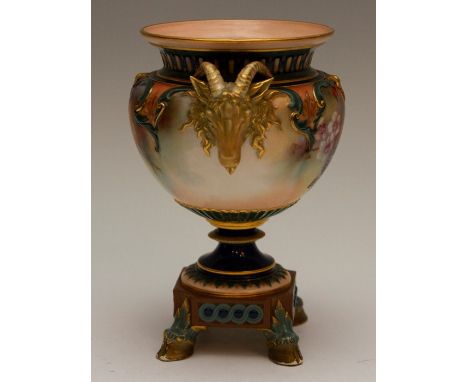 A Hadleys Worcester vase painted with fruit and leaves, with  gilded Rams head handles, standing on a raised base with hoof f