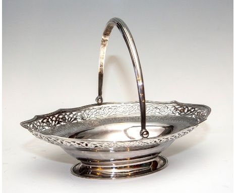 A George III boat shaped silver swing handled basket, scroll pierced border, bright cut engraved and heraldry, collet foot, m