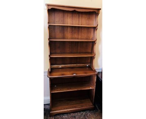 An Ercol elm freestanding open bookcase, of two-tier form, the upper section with three shelves, the lower section with two s