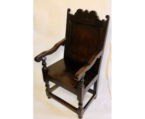 A James II oak wainscot chair, circa 1685, foliate scroll shape cresting rail above moulding single panel back, scrolled arms