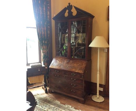 A George III mahogany glazed bookcase bureau, circa 1770, in the manner of Chippendale, crowned with a broken pediment with a
