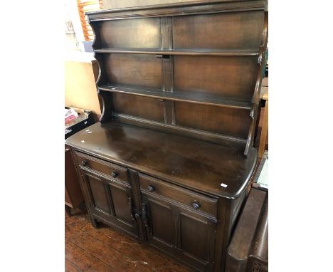 An Ercol elm dresser and rack, two tier shelving above two short drawers and two cupboards.