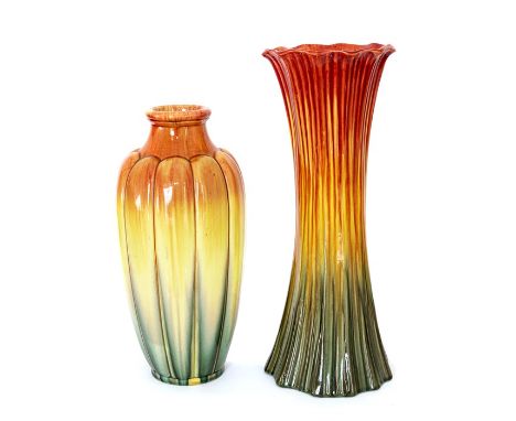 Two Bretby Art Pottery vases of cylindrical form. Both decorated with red, yellow and green glazes to simulate their floral f